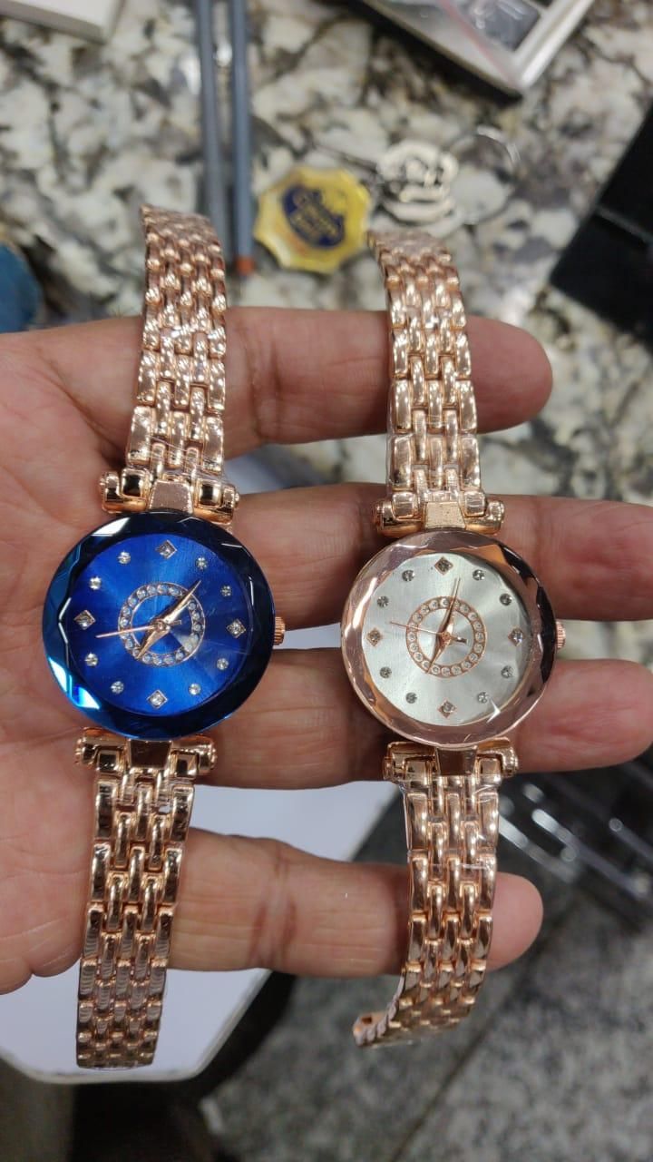 Diamond shaped ladies watch in rose gold with blue and white dials held in hand
